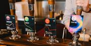 Row of four beer tap hand pumps with pump clips each emblazoned with the Bristol Beer Factory logo and drink name.