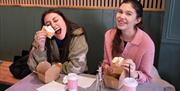 Two women with cakes and coffee