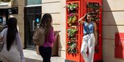 Woman posing in front of a telephone box