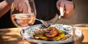 A person eating one of the dishes available at Corkage in Bath.