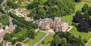 Aerial view of Corsham Court - a grand estate in lawned grounds.