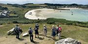 A group of people stood together above a picturesque beach in Cornwall