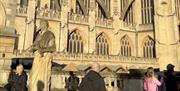 People and tourists looking at an old Abbey in Bath.